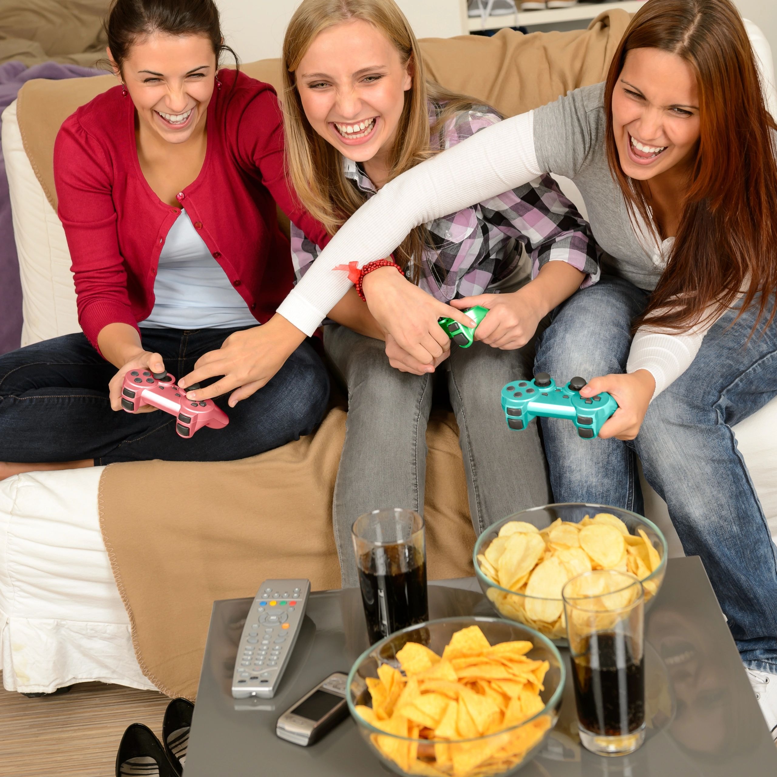 Friends laughing and playing video games together