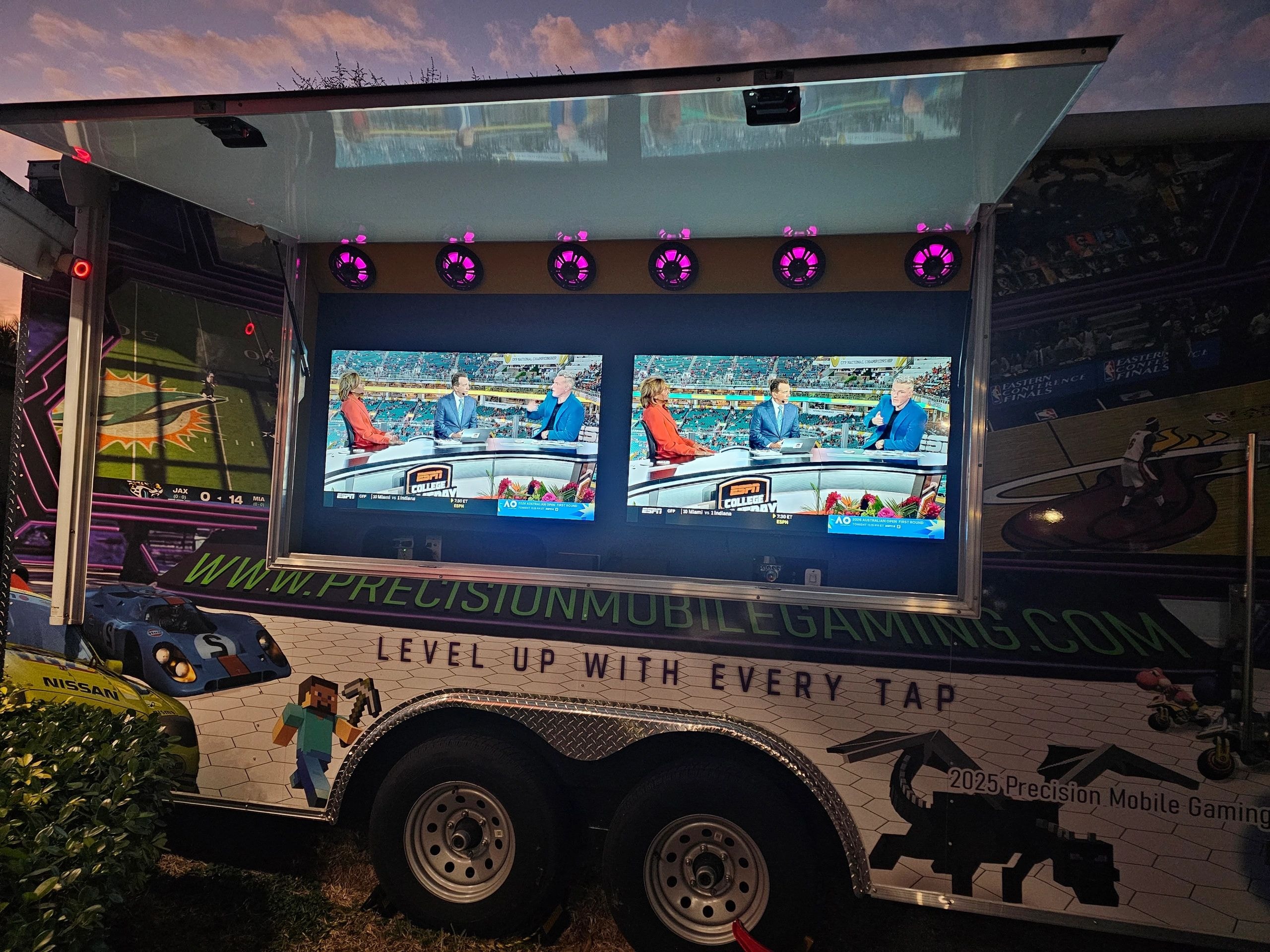 PMG truck open at dusk with dual ESPN College GameDay screens and pink neon lights